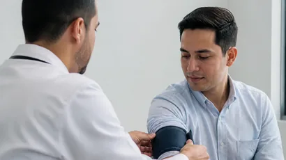 Cardióloga tomando la presión arterial a un paciente en consulta
